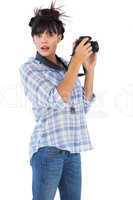 Astonished young woman taking picture with her camera