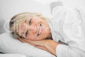 Blonde woman lying in her bed