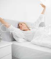 Blonde woman waking up and stetching