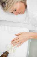 Blonde woman lying motionless after overdosing on tablets