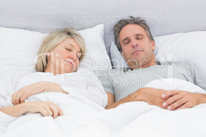 Couple sleeping peacefully in their bed