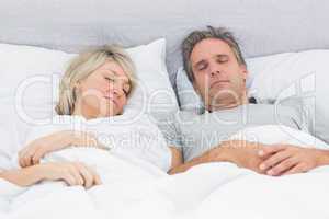 Couple sleeping peacefully in their bed