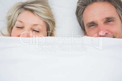 Couple waking up under the covers