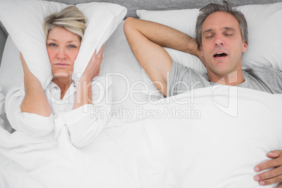 Man snoring loudly as partner blocks her ears