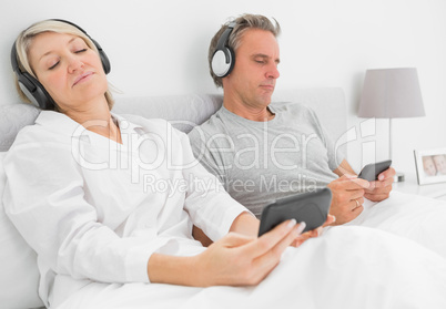 Couple listening to music on their smartphones