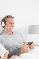 Smiling man listening to music on his smartphone
