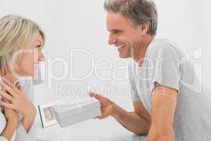 Man giving present to his pleased partner