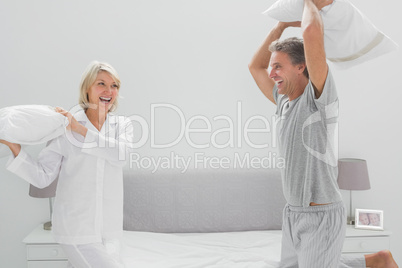 Laughing couple having a pillow fight