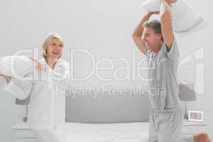 Laughing couple having a pillow fight