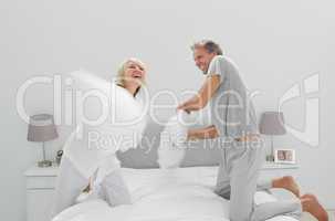 Fun couple having a pillow fight