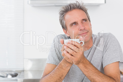 Thoughtful man having coffee in kitchen