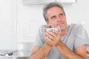 Thoughtful man having coffee in kitchen