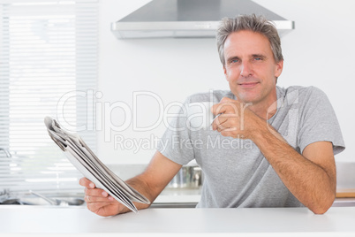 Happy man with coffee and newspaper