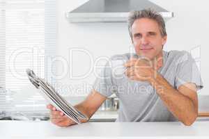 Happy man with coffee and newspaper