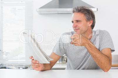 Happy man with coffee reading newspaper