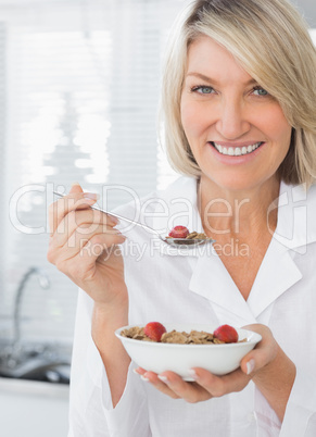 Smiling woman having cereal for breakfast