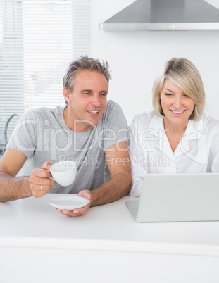 Content couple using laptop in the morning