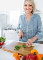 Cheerful woman chopping vegetables
