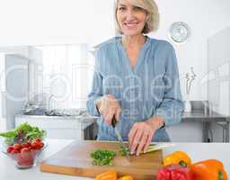 Happy woman chopping vegetables