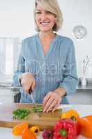 Smiling woman chopping vegetables