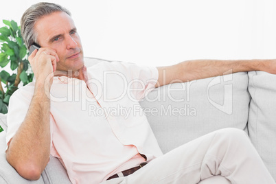 Man on his couch on the phone