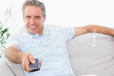 Happy man on his couch watching tv