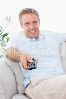 Cheerful man on his couch watching tv