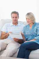 Couple using tablet pc together on the sofa