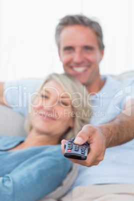 Cheerful couple relaxing at home watching tv