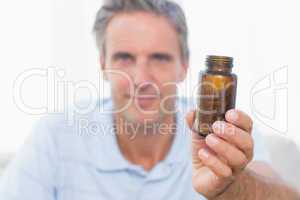 Man showing bottle of pills to camera