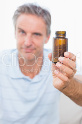 Man showing bottle of tablets to camera