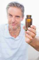 Man showing bottle of tablets to camera