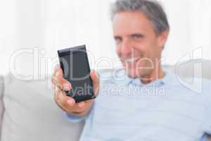 Man showing smartphone to camera