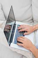 Mans hands typing on laptop