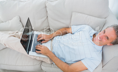 Man typing on laptop at home