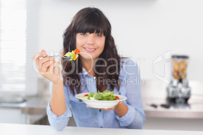 Pretty brunette having a healthy salad for lunch