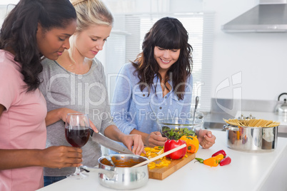 Smiling friends preparing a meal together