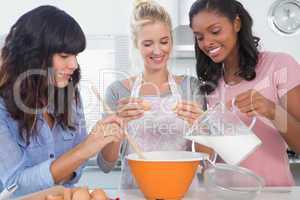 Smiling friends making pastry together