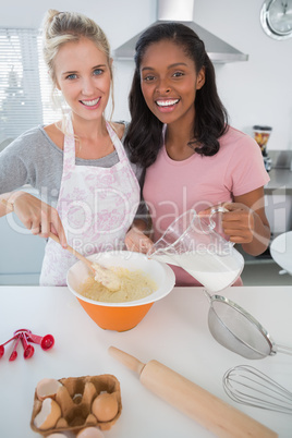 Pretty friends making pastry together looking at camera