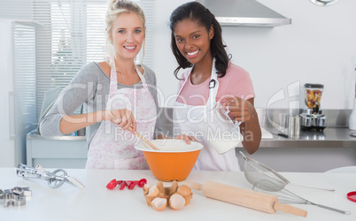 Young friends making pastry together looking at camera