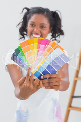 Excited woman showing colour charts and pointing