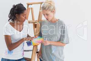 Friendly housemates choosing colour for wall