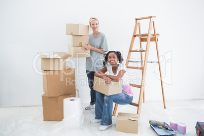 Smiling housemates carrying cardboard moving boxes