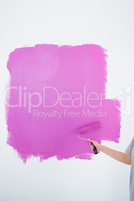 Woman painting her wall pink