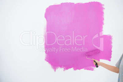 Woman painting her wall in pink