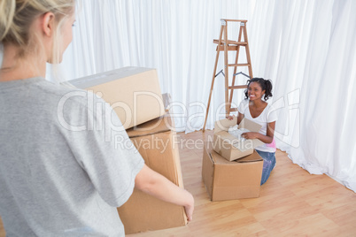 Happy friends unpacking in their new home