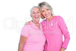 Mature women wearing pink tops and ribbons for breast cancer