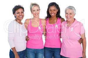 Smiling women wearing pink tops and breast cancer ribbons