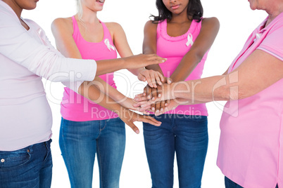 Women wearing breast cancer ribbons with hands together