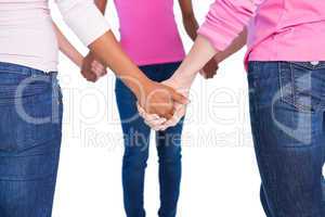 Women wearing pink for breast cancer holding hands